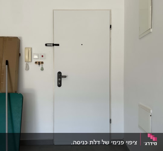דלת לבנה עם מנעול וחפצים ליד